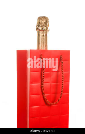 Champagne bottle into red paper gift bag. Isolated on white Stock Photo