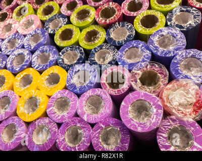 Rolls of decorative wrapping paper of different colors are on the store shelf Stock Photo