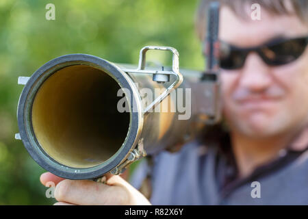 Mercenary in black glasses with anti-tank rocket launcher, RPG in hand. Close-up Stock Photo