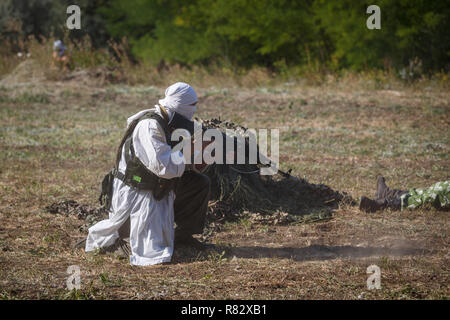 Mujahid sits with a gun in his hands Stock Photo