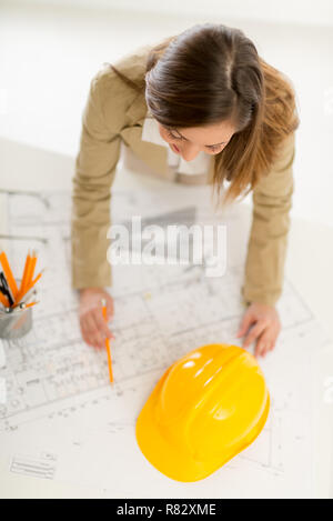 Top view of successful female architect checking the architectural plans. Stock Photo