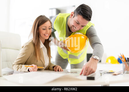 Successful young architects discussing construction plans in office. Stock Photo