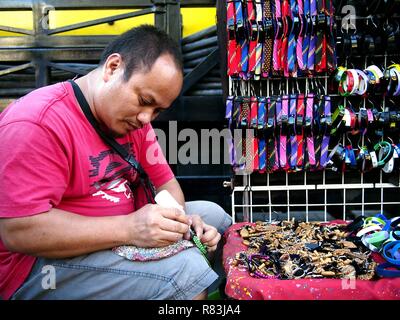 ANTIPOLO CITY, PHILIPPINES - DECEMBER 8, 2018: A vendor sells assorted custom made fashion accessories on a sidewalk. Stock Photo