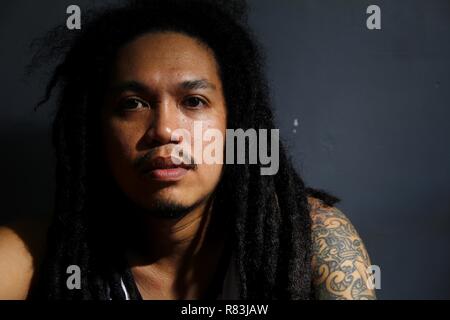 ANTIPOLO CITY, PHILIPPINES - DECEMBER 10, 2018: An adult Filipino man sporting a dreadlocks hairstyle poses for the camera. Stock Photo