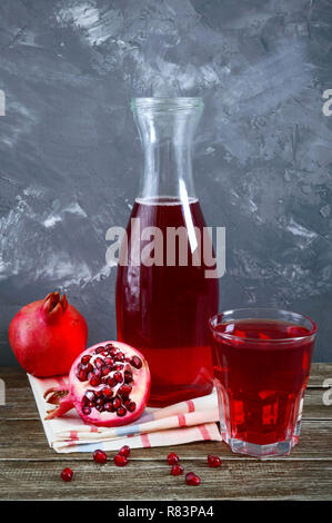 Ripe pomegranate fruit, bottle and glass of fresh pomegranate juice on wooden table. Healthy eating concept. Stock Photo