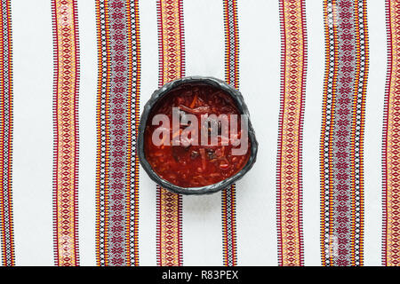 top view of traditional tasty beetroot soup with embroidered towel on background Stock Photo