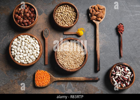 flat lay of wooden bowls and spoons with superfoods, legumes and grains on table Stock Photo