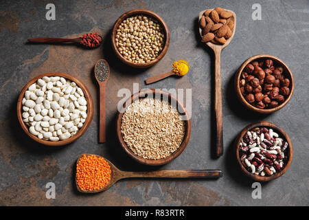 flat lay of wooden bowls and spoons with superfoods, legumes and grains on table Stock Photo