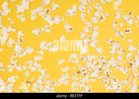 top view of crunchy scattered popcorn isolated on yellow Stock Photo