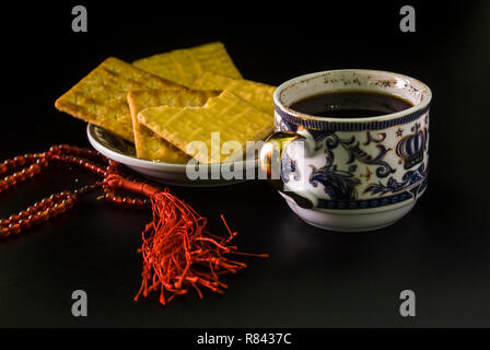 one cup of black coffee and cheese biscuits with rosary ornaments Stock Photo