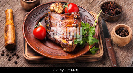 Fried pork ribs with tomato on wooden table Stock Photo