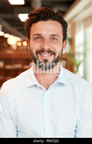 Portrait Of Young Businessman Standing In Modern Office At Graduate Recruitment Assessment Day Stock Photo