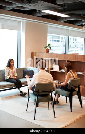Businessman And Businesswoman Interviewing Female Candidate In Office At Graduate Recruitment Assessment Day Stock Photo