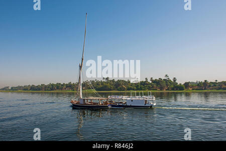 A traditional boat sailing through the Nile River in a late afternoon ...