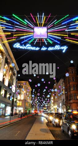 Black Cabs under 2018 Christmas lights along Oxford Street Toward Oxford Circus, Soho, London, UK. Stock Photo