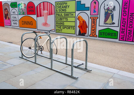 Kings Cross, London, England UK - November 2018: Fixed gear road hipster bike parked in front of billboards promoting the new venue Coal Drops Yard on Stock Photo