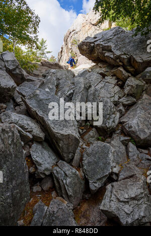 Hiker climbing The Crack, La Cloche Silhouette Trail, Killarney Provincial Park, Ontario, Canada Stock Photo