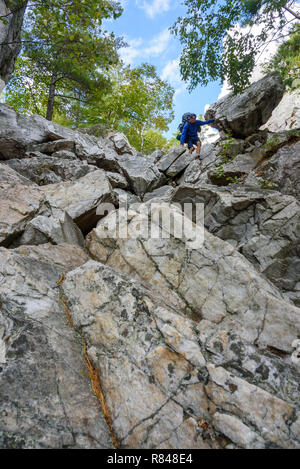 Hiker climbing The Crack, La Cloche Silhouette Trail, Killarney Provincial Park, Ontario, Canada Stock Photo