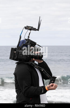 Video camera with wifi router streaming live coverage of surfing event. Stock Photo