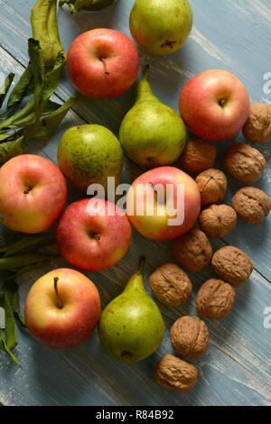 pile of apples, pears and walnuts on blue wooden table - closeup Stock Photo