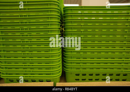 Colorful plastic boxes stacked one upon the other. Multi-colored plastic baskets on the store shelf Stock Photo