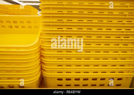 Colorful plastic boxes stacked one upon the other. Multi-colored plastic baskets on the store shelf Stock Photo