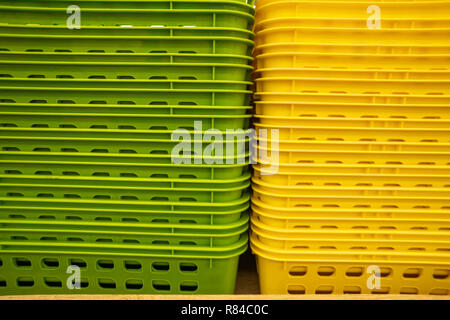 Colorful plastic boxes stacked one upon the other. Multi-colored plastic baskets on the store shelf Stock Photo