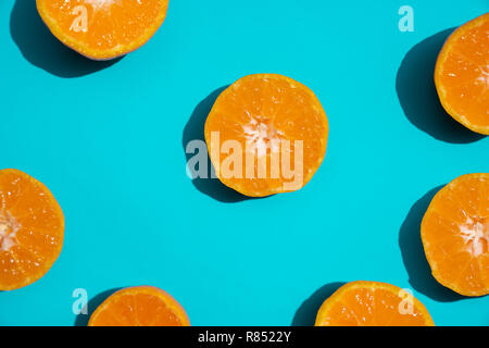 Top view fresh orange slices on bright blue background. Copy Space. creative summer concept. Half of citrus in minimal, Banner Stock Photo