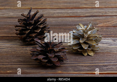 Closeup three pine cones on brown wooden background Stock Photo