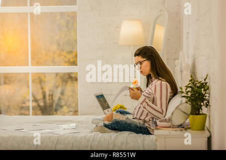 Working while pregnancy. A pregnant woman managing an important process remotely Stock Photo