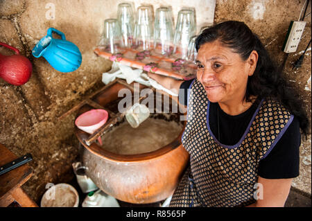 Women are preparing chicha in Chicheria is the place in home , in unused room where local people are drinking refreshing chicha- Inca beer. Stock Photo