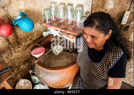 Women are preparing chicha in Chicheria is the place in home , in unused room where local people are drinking refreshing chicha- Inca beer. Stock Photo