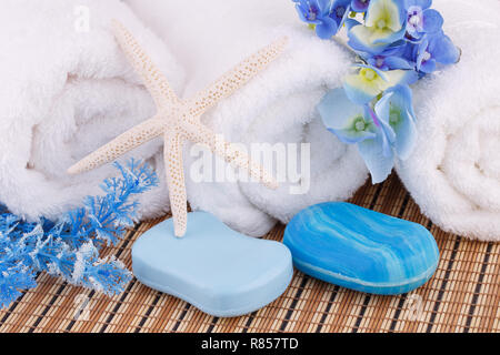 White towels with blue flowers and soaps, starfish closeup picture. Stock Photo