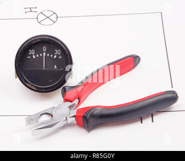 Ammeter and pliers  on a background of the electric scheme Stock Photo