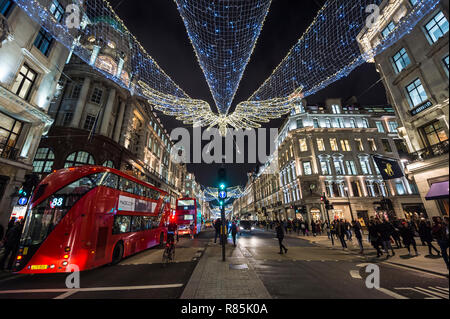 LONDON - NOVEMBER 23, 2018: Black Friday shoppers crowd the sidewalks of the luxury retail district of Regent Street, decorated with Christmas lights. Stock Photo