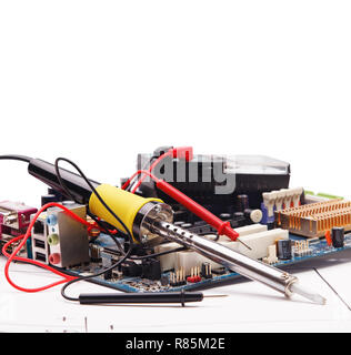 Soldering iron and electronic circuit board on a background of the electric scheme Stock Photo