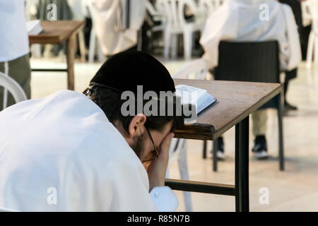 Religious orthodox jew praying at the Western wall and reads the Torah in Jerusalem old city. JERUSALEM, ISRAEL. 24 October 2018. Stock Photo