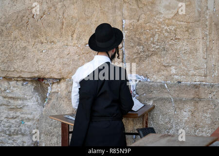 Religious orthodox jew praying at the Western wall and reads the Torah in Jerusalem old city. JERUSALEM, ISRAEL. 24 October 2018. Stock Photo