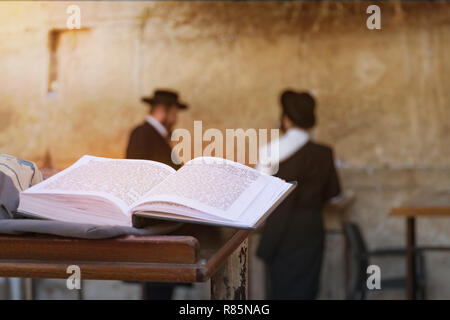Jewish bible on table, wailing western wall, jerusalem, israel. book of the Torah-the Pentateuch of Moses is open on the prayer table on the backgroun Stock Photo