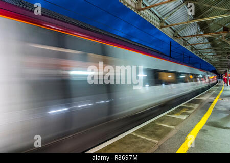 High speed Virgin train passing through Oxenholme Railway Station Stock Photo