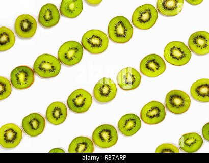 Kiwi fruit slice in diagonal row as pattern. Colorful food pattern for background. Isolated on white. Top view or flat lay. Stock Photo