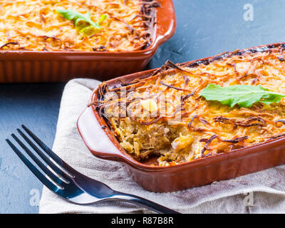 Close up view of appetizing potato casserole with fish, eggs and cream. Potato casserole in serving baking dish on dark concrete background Close up view of appetizing potato casserole with fish, eggs and cream. Potato casserole in serving baking dish on dark concrete background