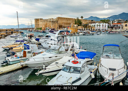 Kyrenia or Girne  historical city center, view to marina with many yachts and boats with Venetian castle and mountains in the background, North Cyprus Stock Photo
