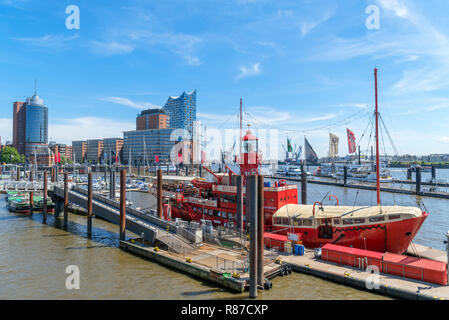 Das Feuerschiff floating restaurant and hotel with the city skyline behind, St. Pauli Landungsbrücken (St Pauli Piers), Hamburg, Germany Stock Photo