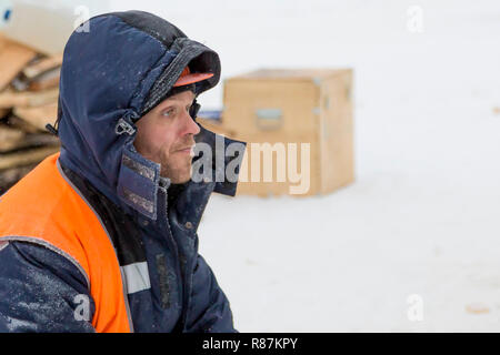 Worker fitter in a protective helmet and reflective vest on the working meast Stock Photo