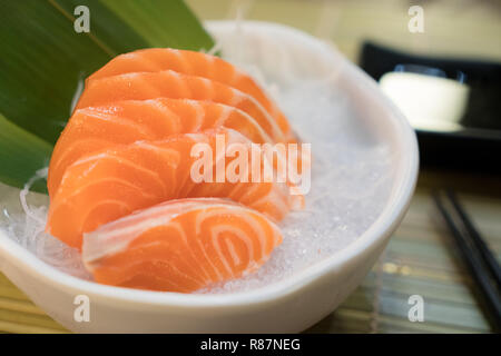 Raw salmon slice or salmon sashimi in Japanese style fresh serve on ice in bowl. Stock Photo