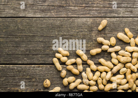 The dried peanuts. Groundnuts on old wooden table. Top view. Stock Photo