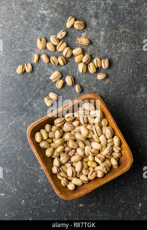 The pistachio nuts in wooden bowl. Top view. Stock Photo