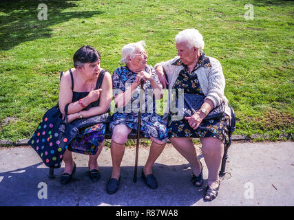 Three elderly women on a bench, senior people sitting on a bench in a park stick Czech Republic Old women talking seniors older generation Stock Photo