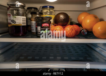 The inside shelf of a Fridge and the contents and one empty shelf that are owned by an 90 year old lady in England Stock Photo